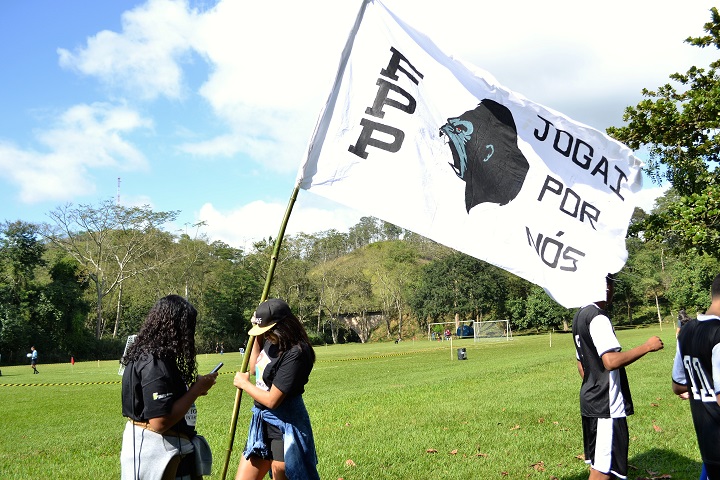 Aluna segura bandeira da torcida organizada do campus