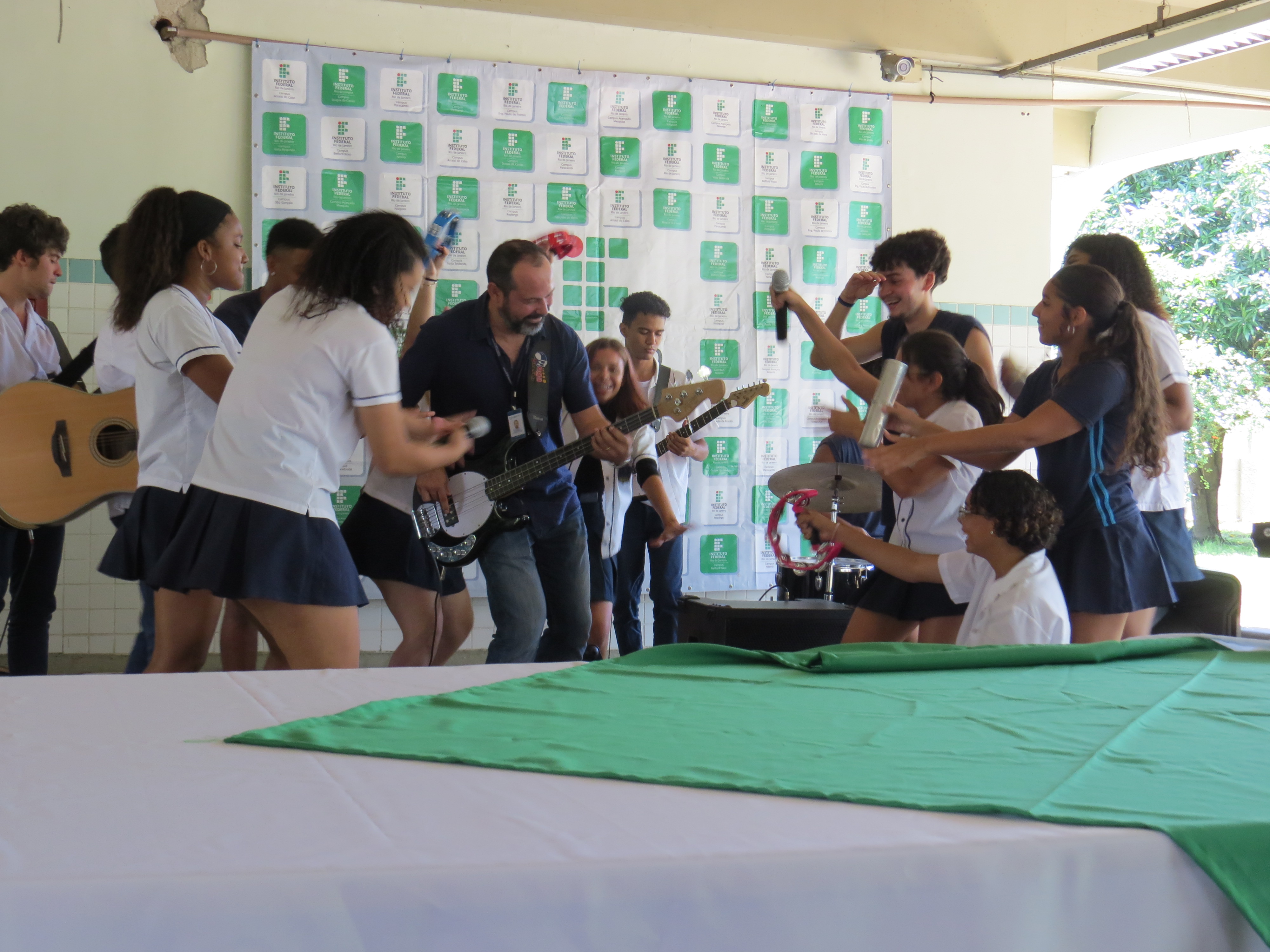 estudantes participando de uma roda de música com uma pessoa cantando e tocando violão