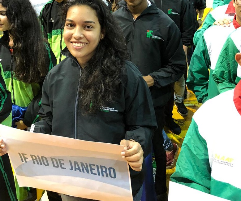 Ana Carolina segunrando cartaz do Rio de janeiro no inicio dos Jogos 