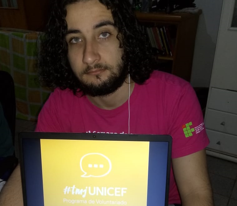 aluno Paulo de frente segurando um laptop com o logo do programa 
