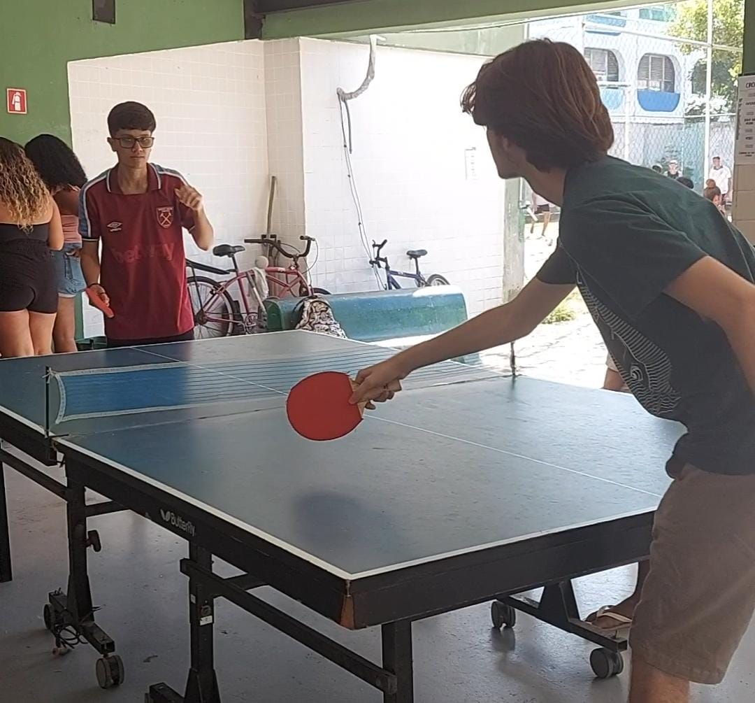 dois alunos jogam ping pong