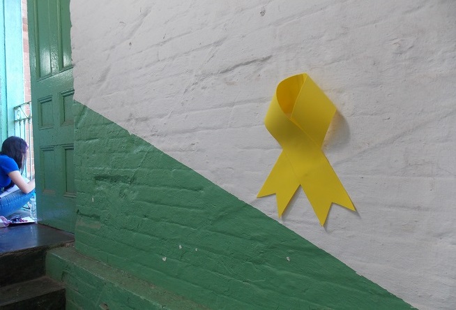 parede branca e verde com símbolo do setembro amarelo